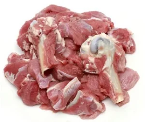 Meat delivery Dubai: Fresh, tender raw meat cuts on a wooden board, ready for cooking, with herbs and spices on the side.